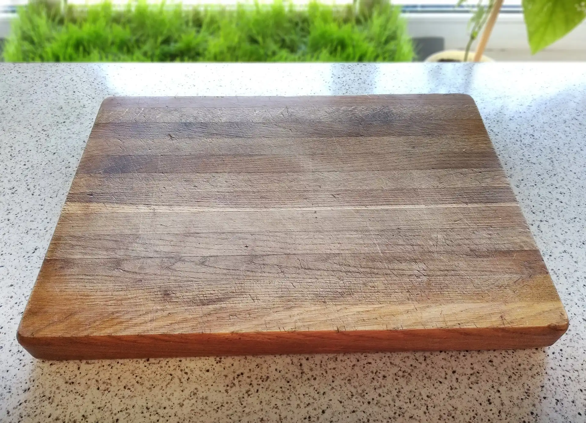Real photo of a used cutting board in the kitchen environment, which lies on the table. This particular chopping-board was used to scan wood texture from.